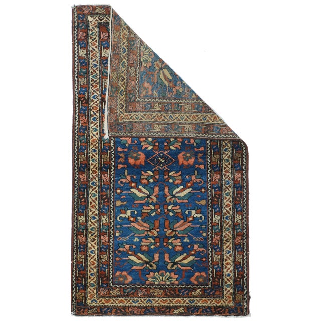 This small west Persian rustic scatter shows a middle blue field decorated by floral modules in cream, green and red,...