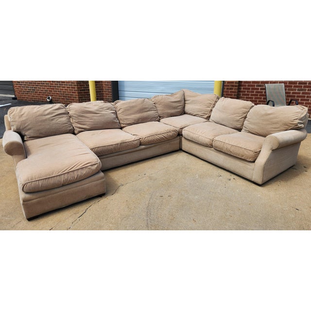 A large four-piece sectional with a contemporary profile and neutral beige upholstery. The set provides generous seating...