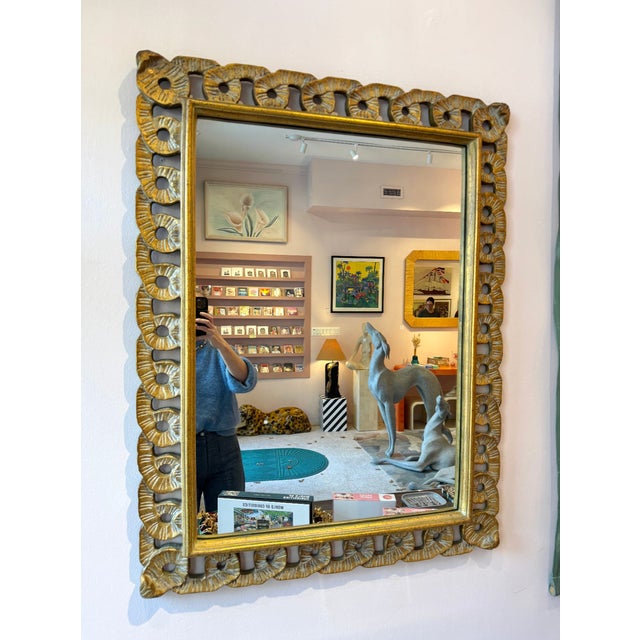 A beautiful vintage Hollywood Regency style wall mirror, with a scalloped chain-link style frame in gold finished wood....