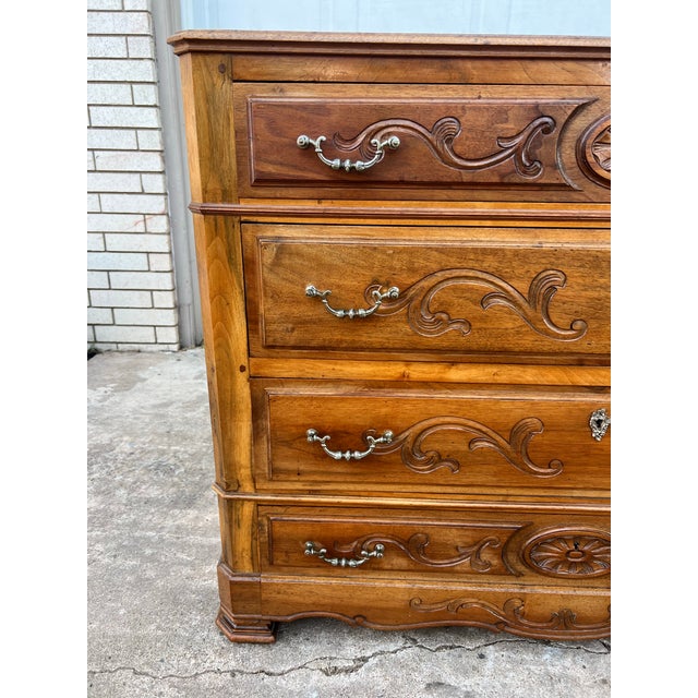 This impressive 19th-century French Louis Philippe walnut commode features four spacious drawers with richly carved floral...