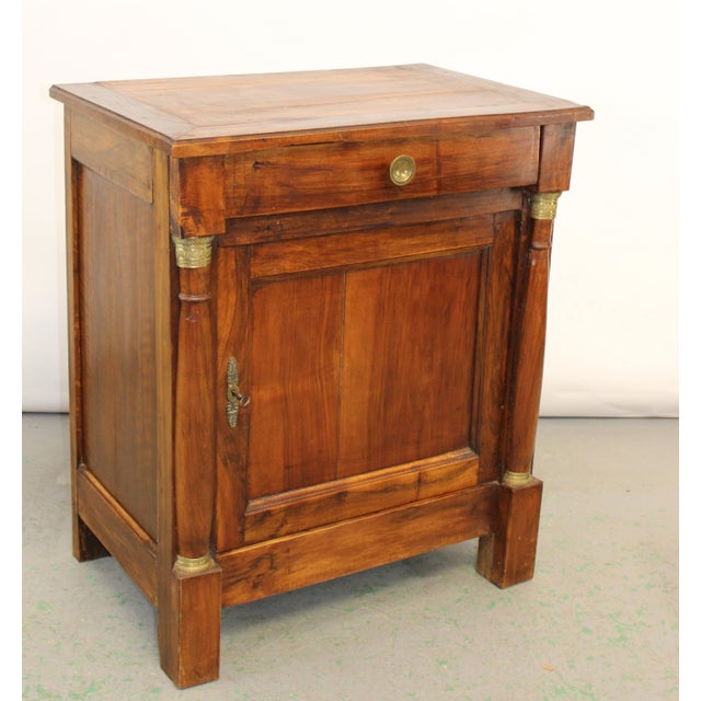 19th Century French Empire Walnut Nightstand with Brass Mounts A handsome 19th-century French Empire bedside cabinet or...