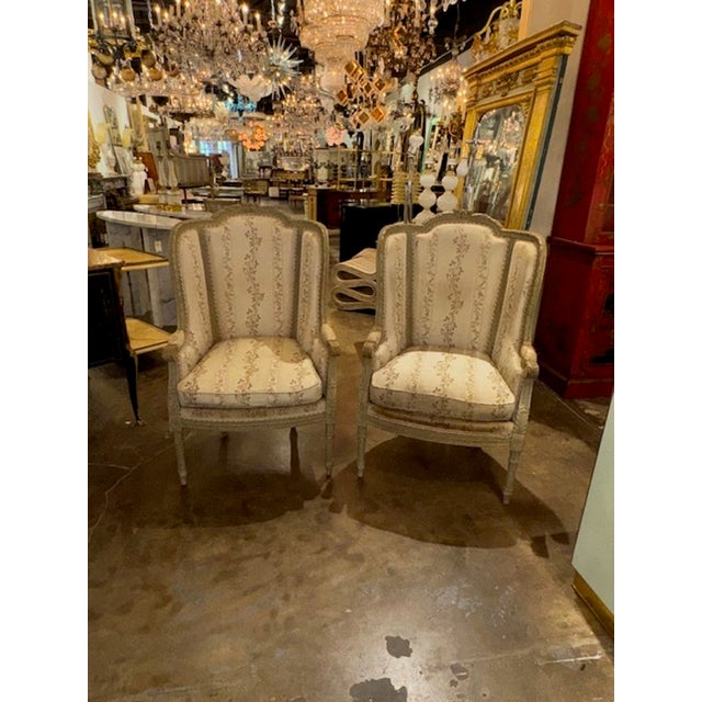 This is a pair of 19th Century French Louis XVI Bergères that feature intricate carvings and a painted finish. The chairs...