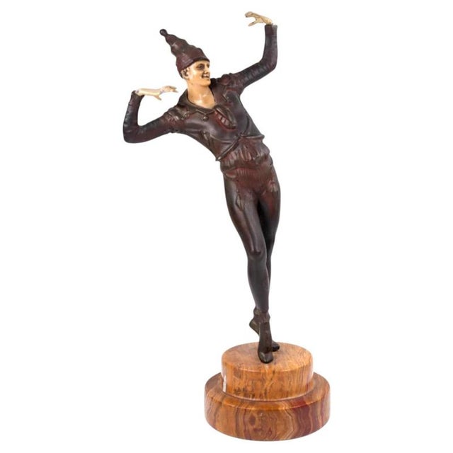 Balancing on the toes of one foot with arms held in sharp, theatrical gestures, this dynamic figure captures the stylized...