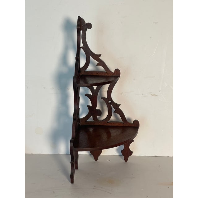 Beautiful light and elegant corner display shelf unit with fret work on wood.