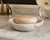 A beautiful hand-carved dish crafted from genuine natural onyx, showcasing elegant layers of creamy ivory, soft beige, and...