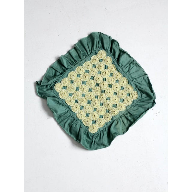Vintage yo-yo quilted pillow cover featuring bright yellow fabric rosettes arranged across a green cotton ground with a...