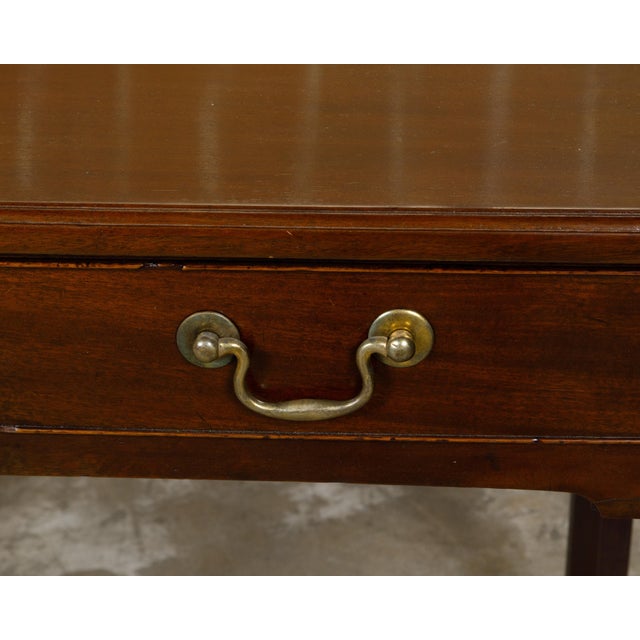 An English Georgian period walnut side table from the 18th century with single drawer, brass hardware and straight legs....