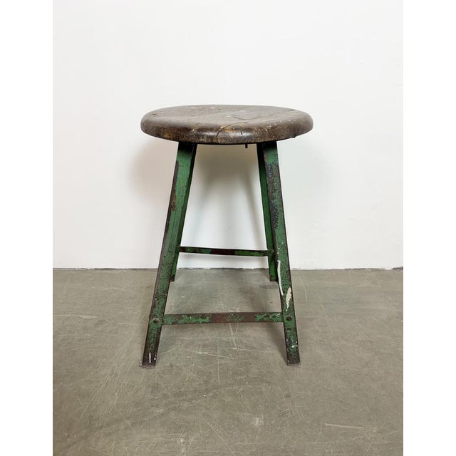 Vintage Industrial factory stool made in former Czechoslovakia during the 1960s It features a wooden seat and a green iron...