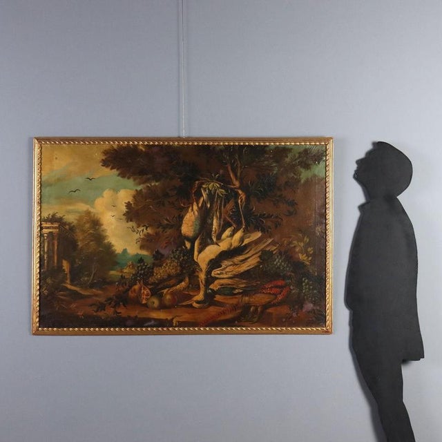 Oil on canvas. This large composition, inspired by ancient models, features game resting on the branches of a tree along a...