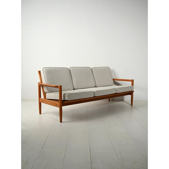 Elegant Scandinavian three-seater sofa, crafted from solid oak between the late 1950s and early 1960s. The simple design...
