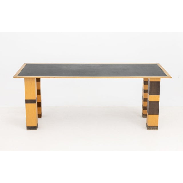 Richard Bloch Dining Table, with inset black linoleum top and striped legs with alternating wood stains. 28.25" H x 73.75"...