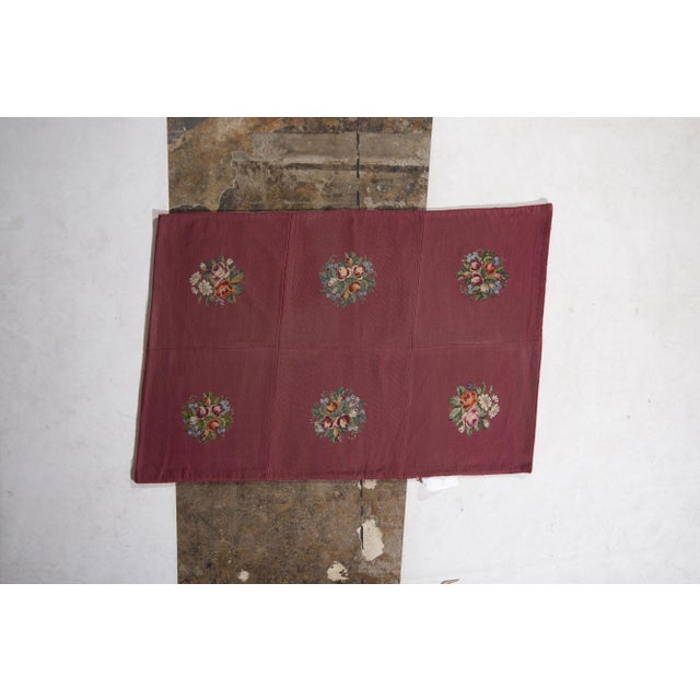 Handmade in wool originating from England circa 1910-1920, this antique rug connotes an early 20th Century needlepoint rug...