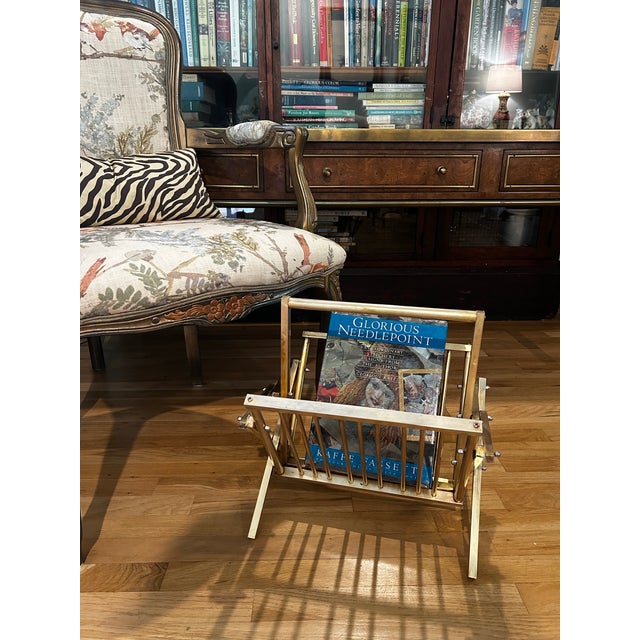 In the style of Mastercraft or Arthur Umanoff, this tubular, folding brass magazine rack will fit right into your mid...
