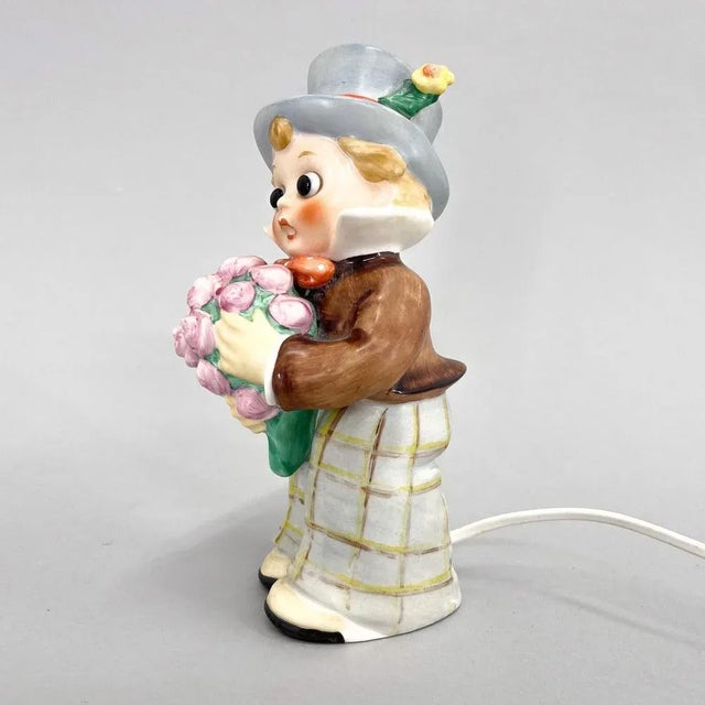 Porcelain figurine of a little boy with flowers as a lamp by Goebel (marked) made in the 1960s in Germany. This piece is...