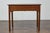 An English Georgian oak table from the 19th century with single drawer and Chippendale style hardware. Elevate any room...