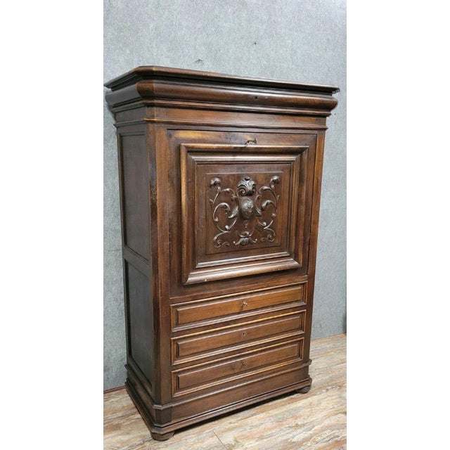 Renaissance-style secretary desk in carved walnut, circa 1850. The front features four drawers and a drop-front. The...