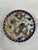 This Chinese plate has a design that depicts birds and cranes and white flowers. The edge of the plate is dark blue with...
