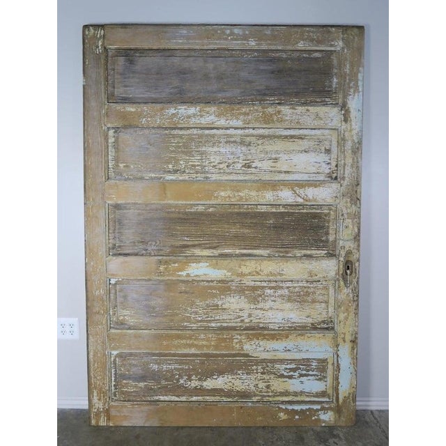 19th century French painted barn door with beautiful worn distressed finish. Cream, blue and remnants of ochre colored...