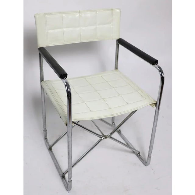 Chic and stylish vintage directors chair with chrome folding frame, wood armrests in black finish, with white vinyl seat...