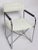 Chic and stylish vintage directors chair with chrome folding frame, wood armrests in black finish, with white vinyl seat...