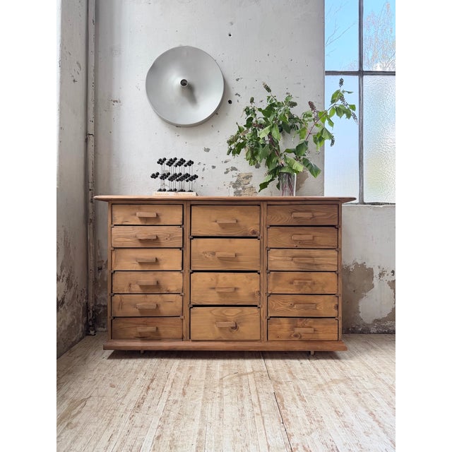 Vintage 1950s pine workshop cabinet. We love its compact design, with its many drawers. the handles are made of wood, the...