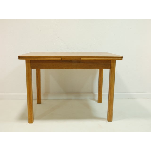 This vintage dining room set from the 1950s consists of an extendable table and four matching chairs, boasting classic...