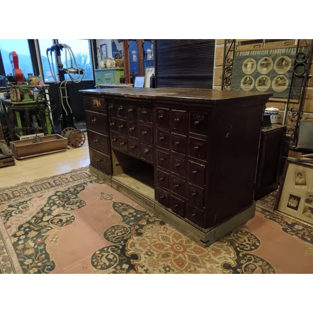 The dark brown or rather burgundy brown counter shown in the pictures once stood in a pharmacy. It consists of display...