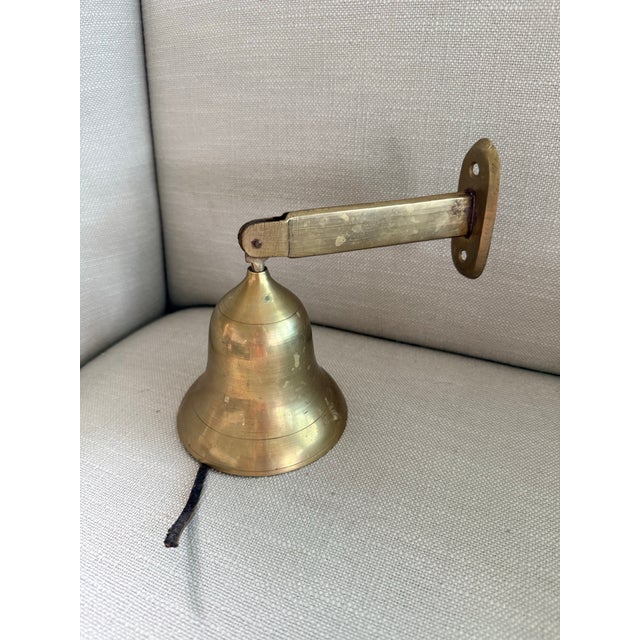 Old wall mount brass ship’s bell. The bell is approx 3.75” wide and it protrudes approx 6” from the wall when hung. A thin...