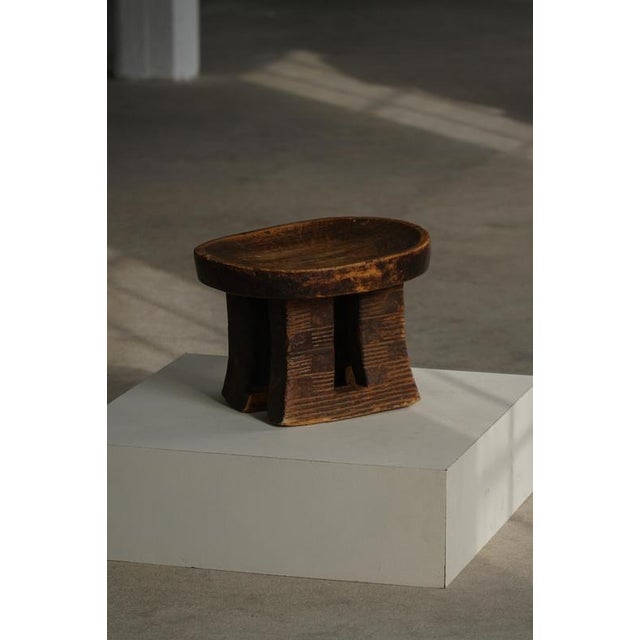 A fine hand‑carved African stool dating to the mid‑20th century, beautifully executed from a single piece of dense...