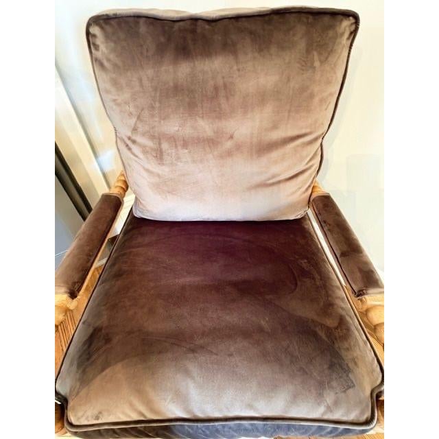 A Bobbin- frame lounge chair with natural oak finish and plush mocha velvet cushions. With tailored piping and sculptural...