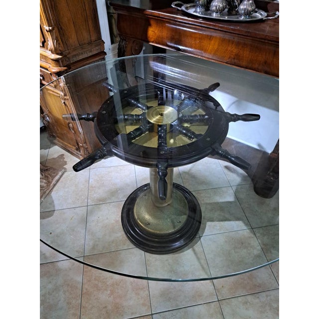 Nautical Table with Rudder – Brass Base, Glass Top. Original nautical-style table featuring a nautical rudder, a central...