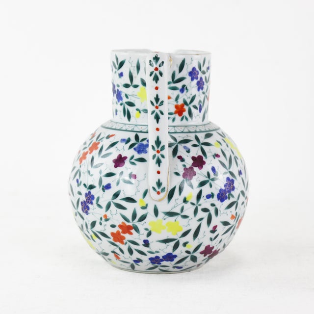 Bring a touch of nature into your home with this stunning vintage-inspired ceramic pitcher, adorned with vibrant hand-...