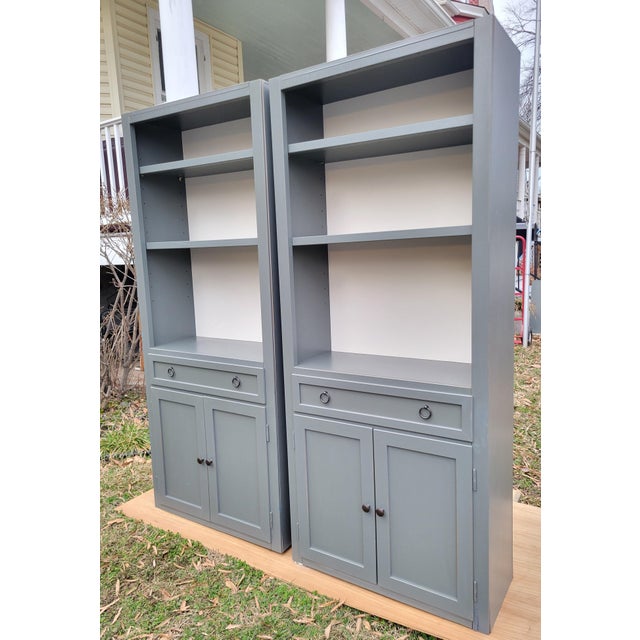 This pair of tulipwood storage bookcases from Crate & Barrel are made in Italy with a hand-painted blue-gray distressed...