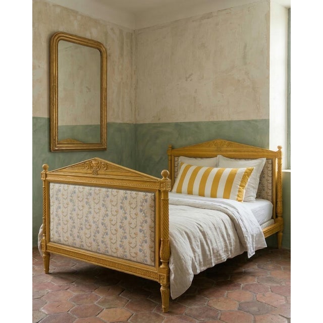 A charming and dreamy french hand-carved bed frame in a soft mustard yellow finish, featuring elegant floral cotton...