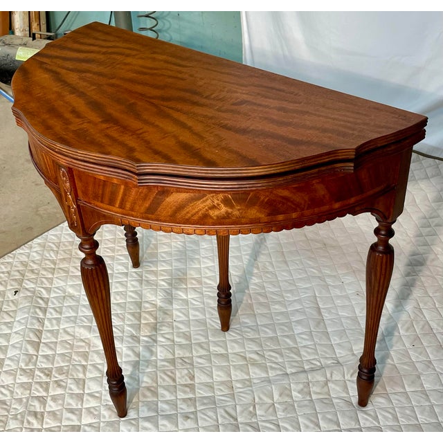 Offered is a regency style Mahogany Card Table with hinged semi circular shape, on tapering fluted legs. Folded the game...