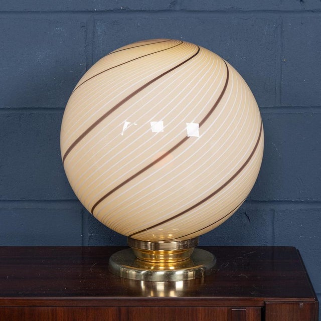 A striking Murano glass globe table lamp, produced in Venice, Italy, circa 1980. The large spherical shade is beautifully...