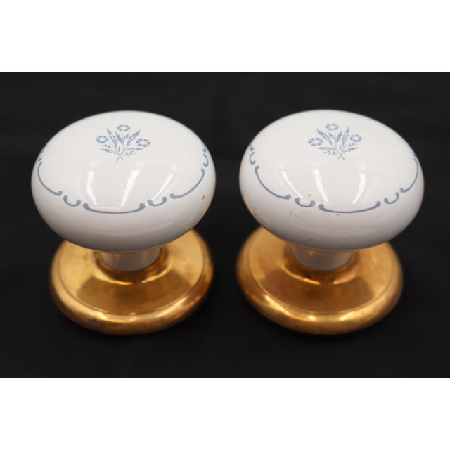 This vintage dummy door knob set includes two white ceramic door knobs with a blue and white floral motif and two polished...