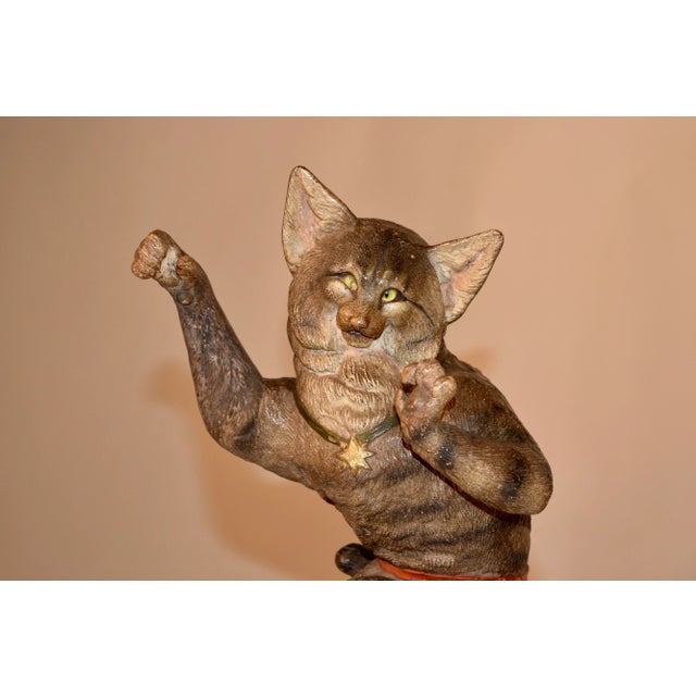 19th century Austrian terracotta cat figure with hand polychromed finish and glass eyes. The cat has a striped coat and is...