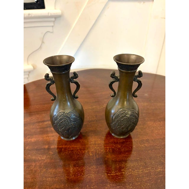 An exquisite pair of Japanese Meiji-period bronze vases beautifully cast and finely detailed. Each vase displays an...