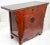 Chinese Ming style hand painted red and brown lacquered cabinet with carved sides, drawer and doors. The piece features...