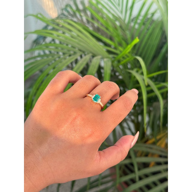 This elegant engagement ring features a 1.09 ct emerald-cut emerald, set in 14K yellow gold. The emerald measuring 7 x 5...