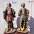 Pair of carved and polychrome wooden sculptures depicting two elegant young figures standing, dressed in short, belted...