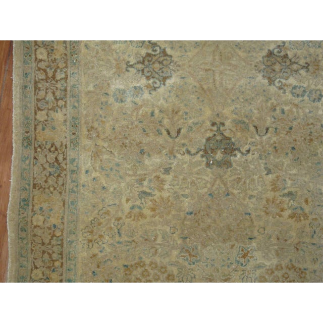An elegant antique Persian Kirman (Kerman) runner with predominant khaki brown and celadon accents set on a shiny cream...