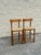Pair of wood bar stools with woven rush seats. Each stool has a curved horizontal back rail, round legs, and lower...