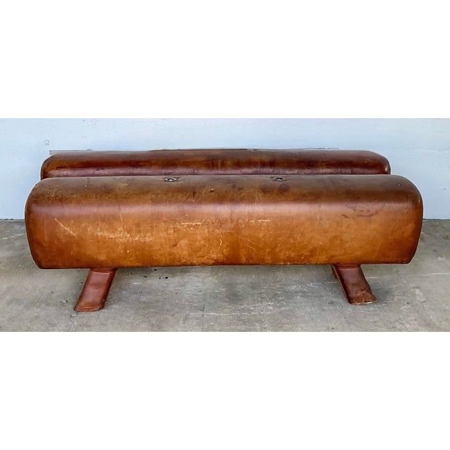 This rare set of two vintage leather pommel horses brings a sophisticated industrial and athletic aesthetic to any curated...