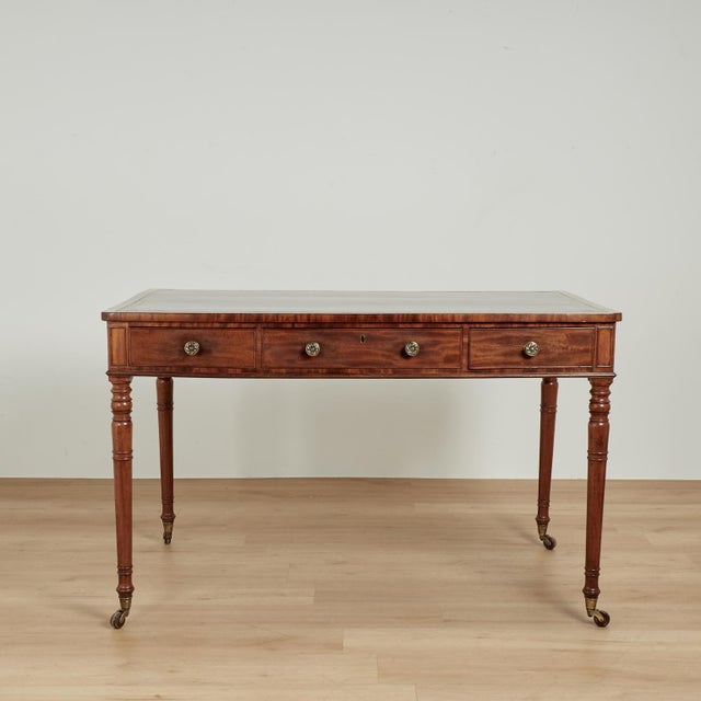 Handsome early 19th century English desk or writing table handcrafted in mahogany with a tooled green leather top on a...