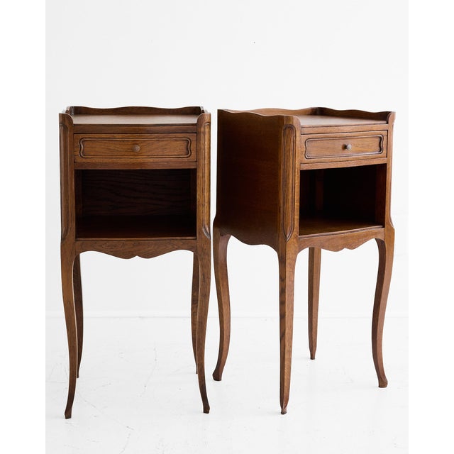 A pair of French oak bedside tables in the Louis XV manner, dating to 1910 and typical of the high-quality provincial...