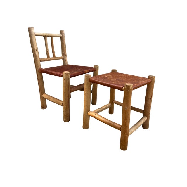 A charming rustic set of one side chair and one matching stool, handcrafted from natural peeled log wood in the classic...