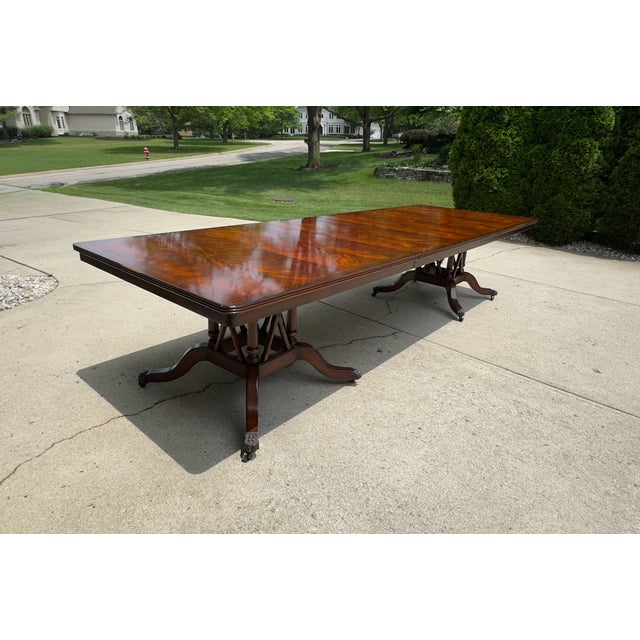 Almost 12 feet long, this very grand Old World table boasts a flame mahogany match book top and 2 pedestals adorned with...
