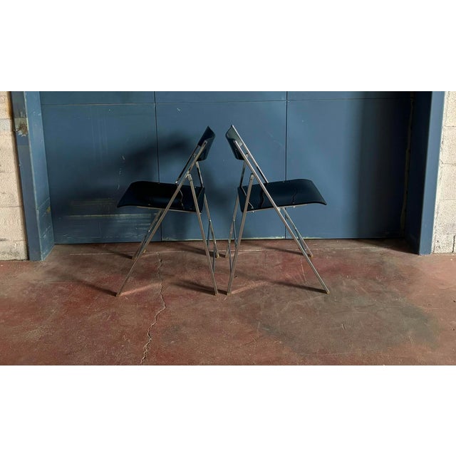 A set of 6 heavy and sturdy folding chairs, with smokey/black acrylic seats and backrests, on a chrome plated steel base....